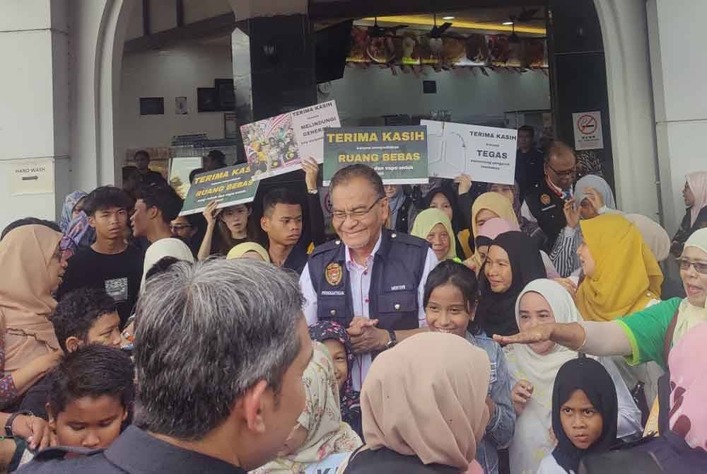 Dr Dzulkefly bersama kanak-kanak memegang pelekat kesihatan semasa melakukan tinjauan Premis Bersih, Bebas Asap Negeri Selangor di Grandeur Labs, Puncak Alam pada Ahad.