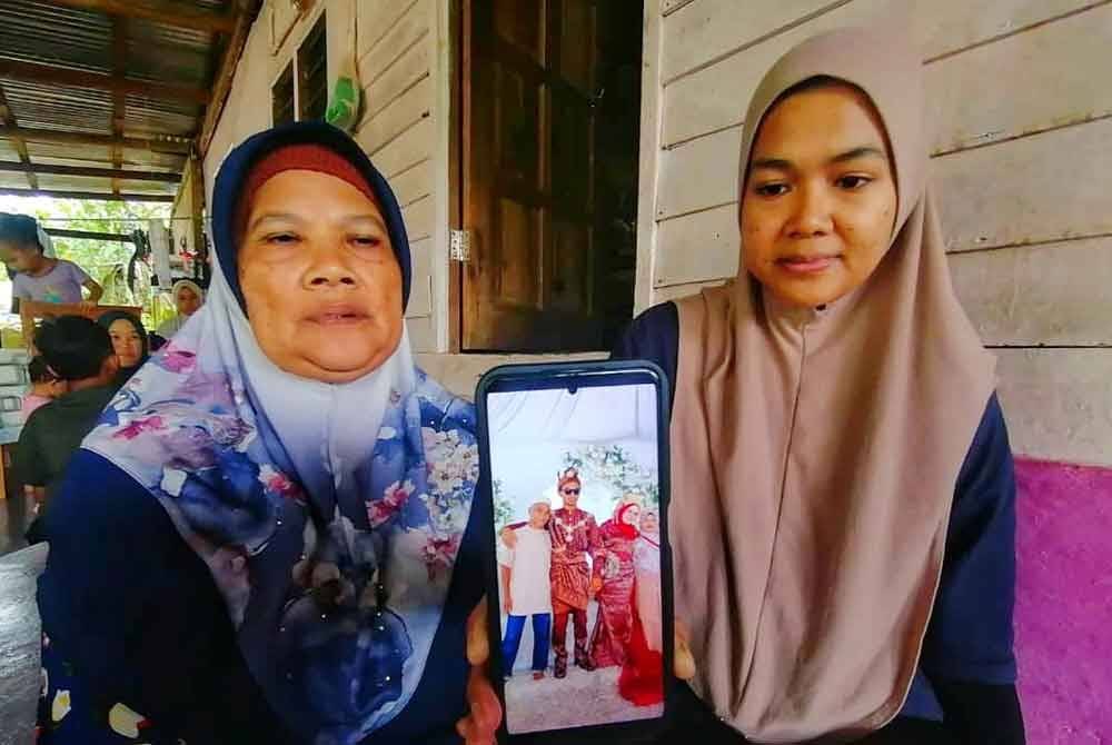 Siti Dayang bersama ibunya, menunjukkan gambar arwah bapanya yang dirakam ketika majlis perlahwinan adiknya pada 7 September lalu.