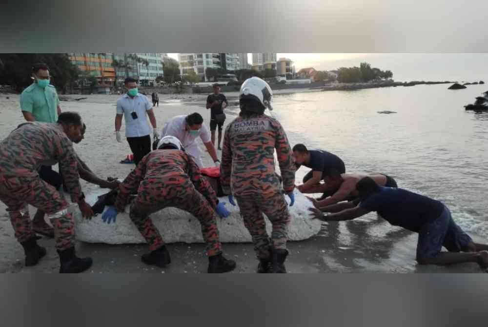 Pasukan bomba membawa mayat seorang lelaki naik ke darat sebelum diserahkan kepada pihak polis.