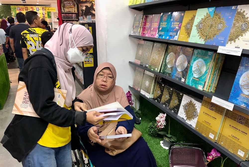 Salah seorang pengunjung bertanya kepada petugas jualan gudang mengenai buku yang diminati.