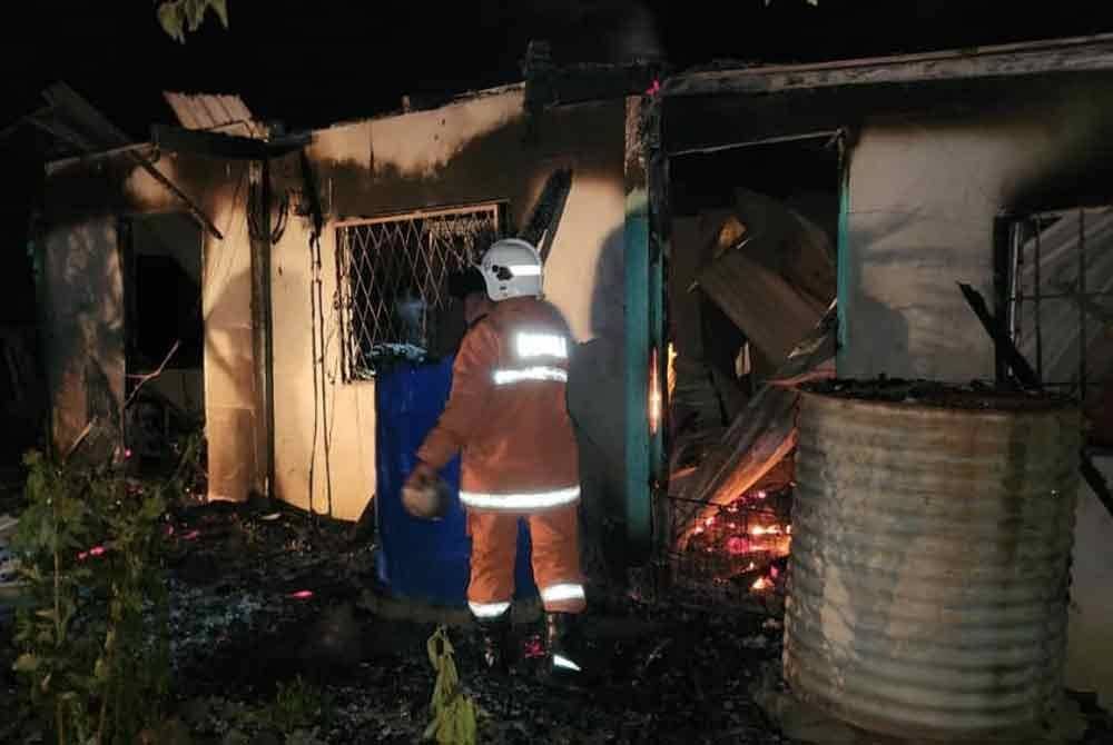 Pasukan bomba melakukan pemeriksaan susulan terdapat seorang rentung dalam kejadian kebakaran rumah di Kampung Pituru, Kudat.