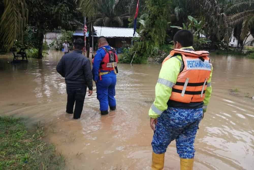 Anggota APM meninjau keadaan banjir kilat di kawasan rumah penduduk. Foto APM Johor