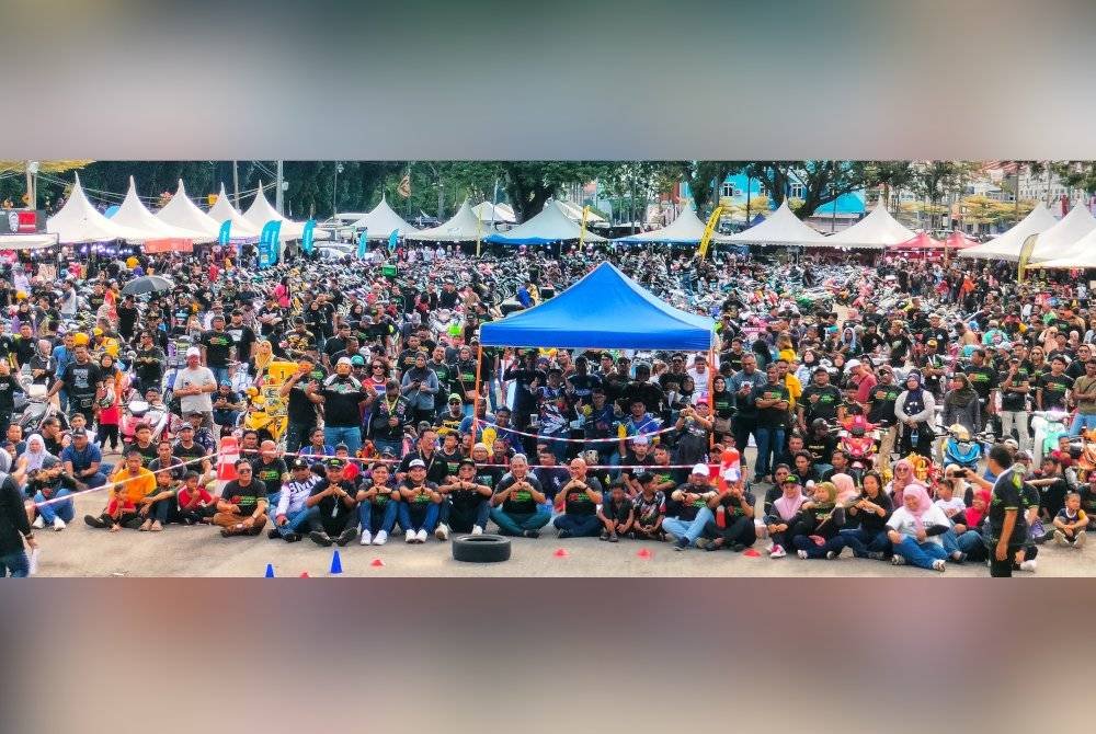 Fadzli (tengah) bersama ribuan peminat pemotoran bergambar kenangan di Dataran Temerloh pada Ahad.