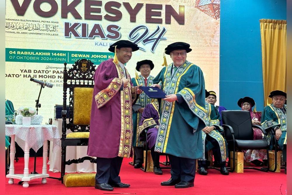 Mohd Amar (kanan) yang menerima penganugerahan Ijazah Kehormat Doktor Pengurusan KIAS disampaikan oleh Mohd Nassuruddin.