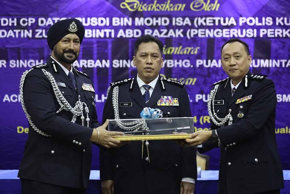 Aidil (kanan) dilantik sebagai Ketua Polis Daerah Cheras baharu menggantikan Ravindar Singh dengan disaksikan Rusdi.