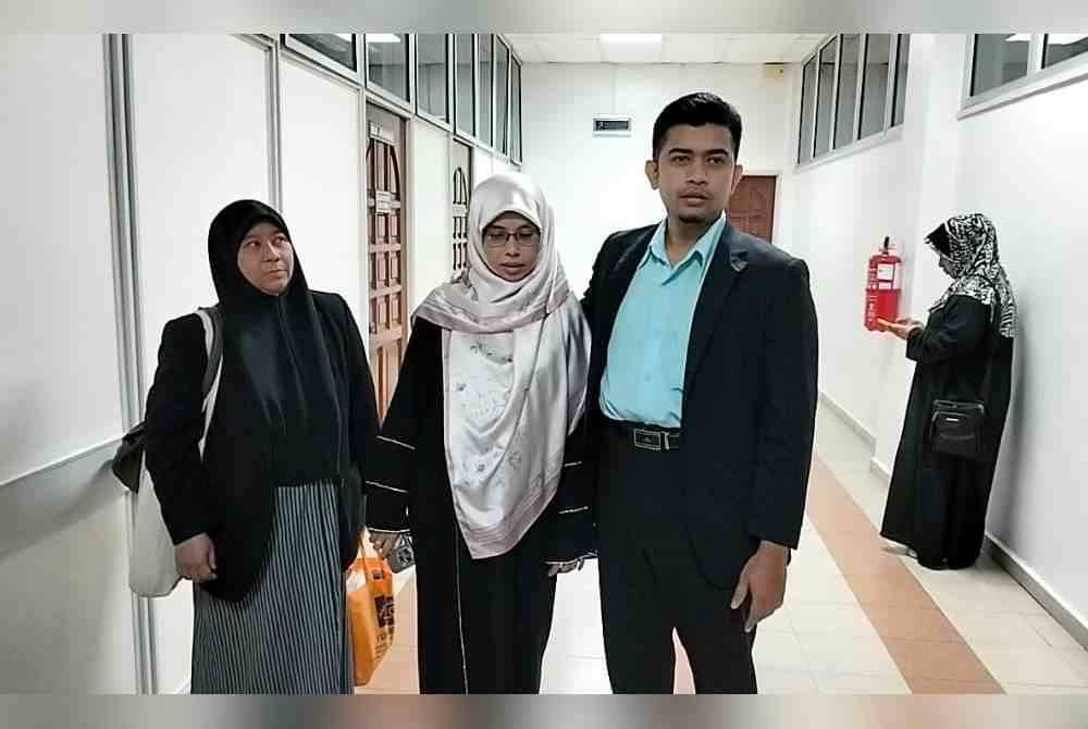 Muhammad Zaki (kanan) dan isteri, Masyitah Md Hassan (tengah) bersama Asiah selepas Mahkamah Sesyen Kuala Kangsar memutuskan untuk melepas dan membebaskan daripada pertuduhan menyebar berita palsu di sini pada Jumaat.