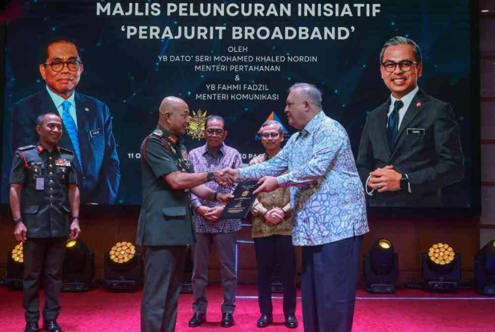 Mohamed Khaled (tengah) bersama Fahmi (dua dari kanan) menyaksikan Penyerahan Memorandum Persefahaman antara ATM yang diwakili oleh Panglima Angkatan Tentera Jeneral Tan Sri Mohammad Ab. Rahman (kiri) dan MCMC yang diwakili oleh Pengerusinya Tan Sri Mohamed Salim Fateh Din (kanan) pada Majlis Peluncuran Inisiatif &#039;Perajurit Broadband&#039; dan Penyerahan Memorandum Persefahaman antara ATM dan MCMC di Auditorium Wisma Pertahanan di Kuala Lumpur pada Jumaat. Foto Bernama