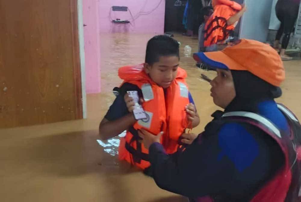 Anggota APM memindahkan mangsa terjejas banjir di Sik ke tempat selamat. Foto: APM