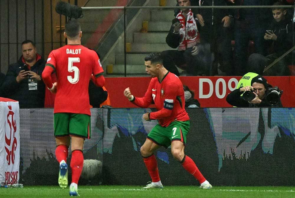 Ronaldo (kanan) meraikan jaringannya ketika menentang Poland. Foto AFP