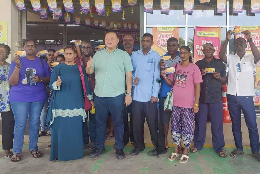 Rizam (depan, tiga dari kiri) bergambar bersama penerima semasa Majlis Penyampaian Baucar Deepavali di sebuah pasar raya di sini pada Isnin.