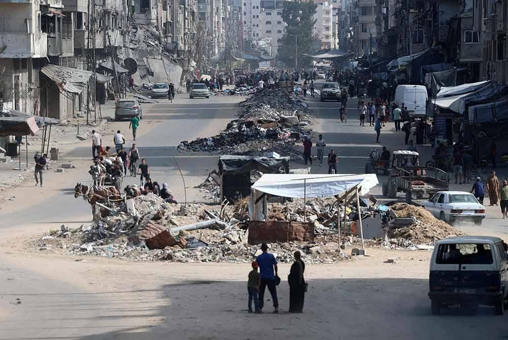 Rakyat Palestin membawa barang-barang mereka ketika melarikan diri dari kawasan utara bandar Gaza. Foto AFP