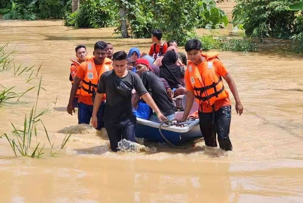 Anggota APM Kedah memindahkan mangsa terjejas ke tempat selamat. Foto APM