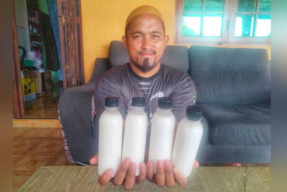 Muhammad Ikram menunjukkan susu kambing saanen yang ditempah pelanggan dimana setiap sebotol dijual pada harga RM5.