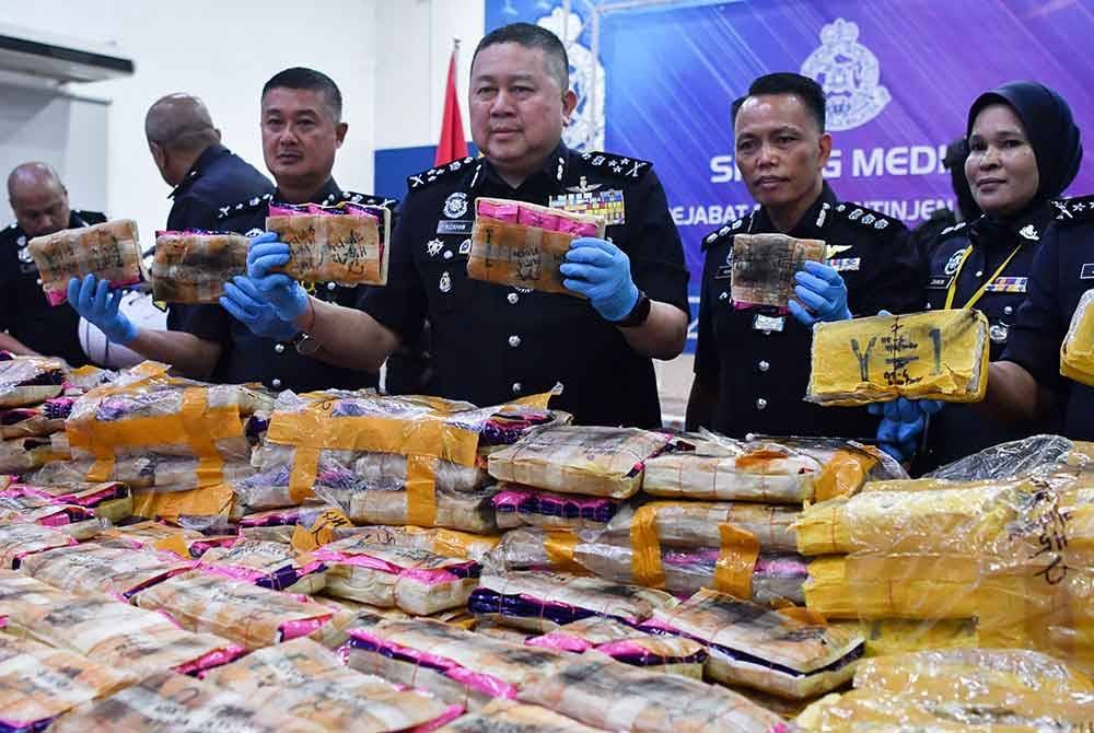 Kok Chin (tengah) bersama pegawai menunjukkan sebahagian lebih 600 kilogram pil yaba dan heroin yang dirampas pada sidang media di IPK Kelantan hari ini. Foto Bernama