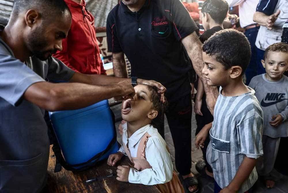 Kanak-kanak Palestin menerima titisan sebagai sebahagian daripada kempen vaksinasi polio, di Deir al-Balah di tengah Semenanjung Gaza ketika perang berterusan antara Israel dan Hamas. - Foto: AFP