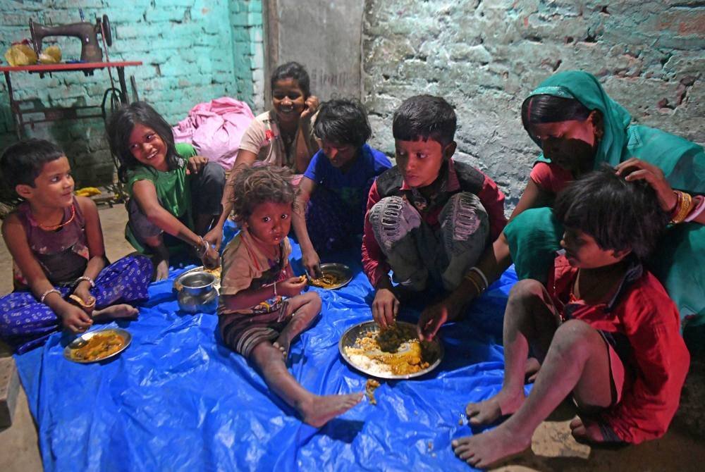 Sebuah keluarga dari daerah Darbhanga berkumpul untuk makan bersama ketika India dikelaskan mempunyai penduduk termiskin paling ramai. - AFP