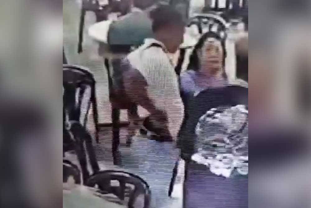 Tangkap layar video tular menunjukkan seorang lelaki mengacukan objek menyerupai pistol akibat salah faham di sebuah medan selera di Puchong, Selangor pada Ahad.