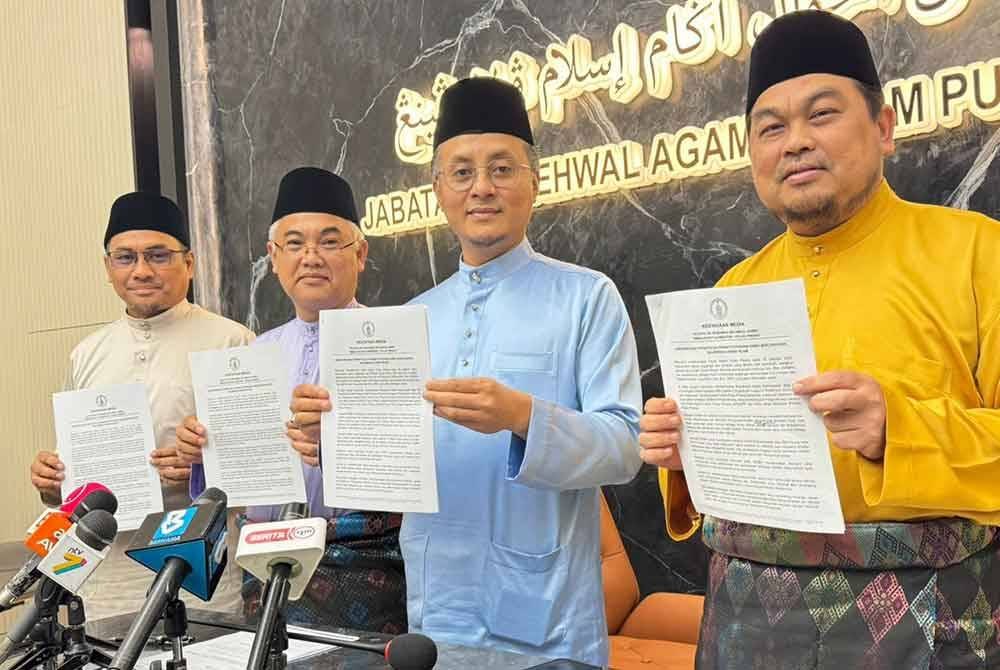 Mohamad (dua dari kanan) bersama Mohd Sukki (kanan) dan Marzuki (dua dari kiri) menunjukkan kenyataan media mengenai keputusan Jawatankuasa Fatwa Negeri Pulau Pinang.