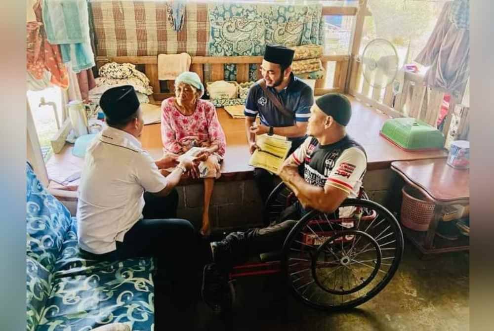 Kumpulan Operasi Agihan Daerah Sepang ketika mengunjungi keluarga Azman (kanan).