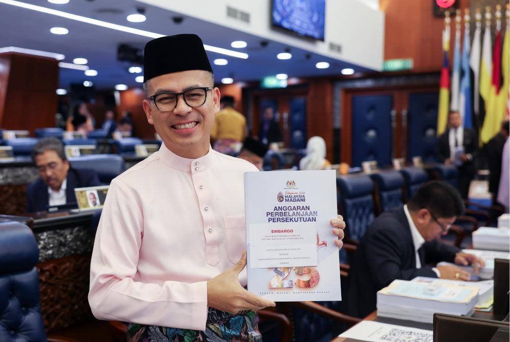 Fahmi menunjukkan buku Belanjawan 2025 ketika menghadiri pembentangan Belanjawan 2025 oleh Perdana Menteri Datuk Seri Anwar Ibrahim, pada Jumaat. Foto Bernama