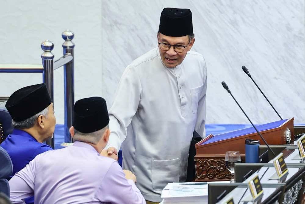 Anwar bersalaman dengan timbalannya Datuk Seri Dr Ahmad Zahid Hamidi dan Datuk Seri Fadillah Yusof sebelum membentangkan Belanjawan 2025 Malaysia Madani di Dewan Rakyat pada Jumaat. Foto Bernama