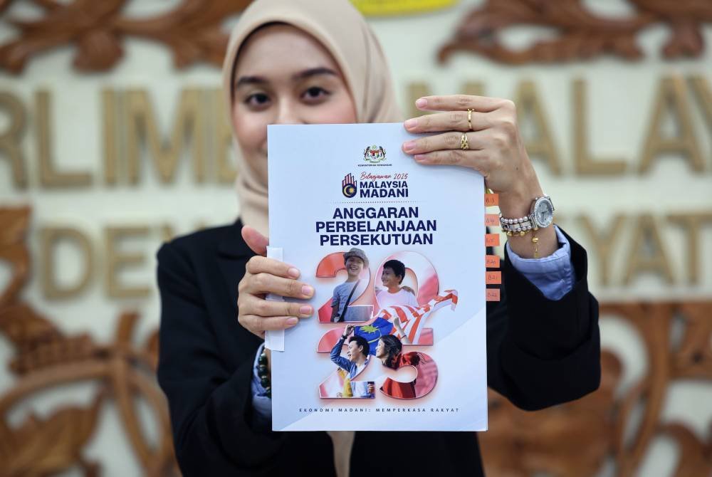 Penjawat awam Sarah Anniesya memegang buku Anggaraan Perbelanjaan Persekutuan selepas pembentangan Belanjawan 2025 Malaysia MADANI oleh Perdana Menteri yang juga Menteri Kewangan I Datuk Seri Anwar Ibrahim di Dewan Rakyat hari ini. Foto Bernama