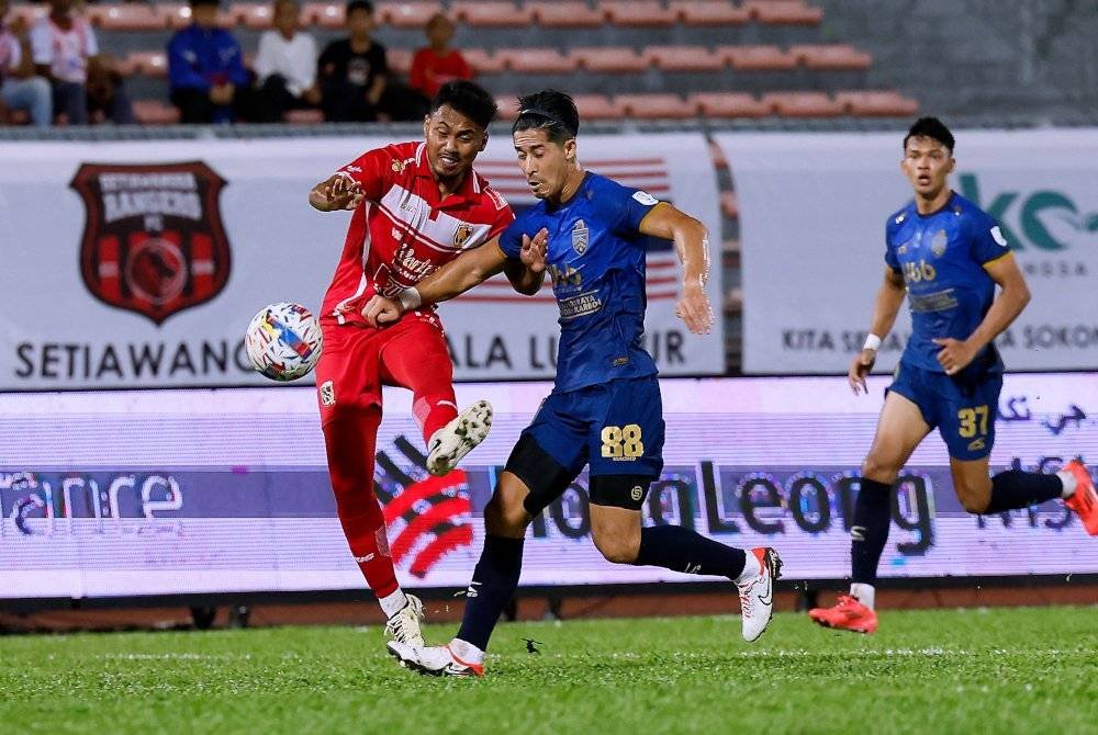 Pemain Kuala Lumpur City FC Brendan Gan (dua dari kanan) cuba mengawal pergerakan pemain Kelantan Darul Naim FC pada Liga Super di Stadium Bola Sepak Kuala Lumpur malam ini. Foto Bernama