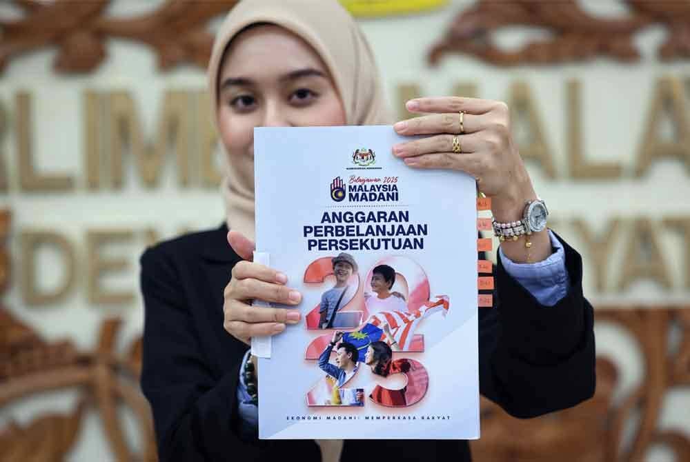 Penjawat awam Sarah Anniesya memegang buku Anggaran Perbelanjaan Persekutuan selepas pembentangan Belanjawan 2025 Malaysia Madani oleh Perdana Menteri yang juga Menteri Kewangan I, Datuk Seri Anwar Ibrahim di Dewan Rakyat. Foto Bernama