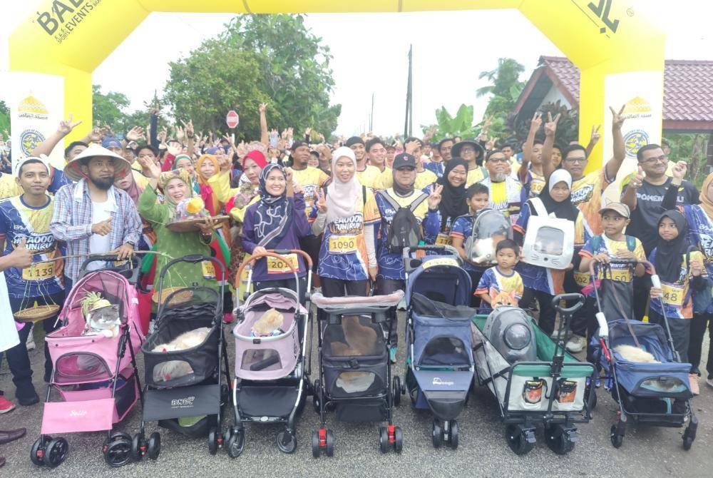 Sebahagian peserta larian sawah membawa kucing masing-masing bersiap sedia semasa acara pelepasan pada Ahad.