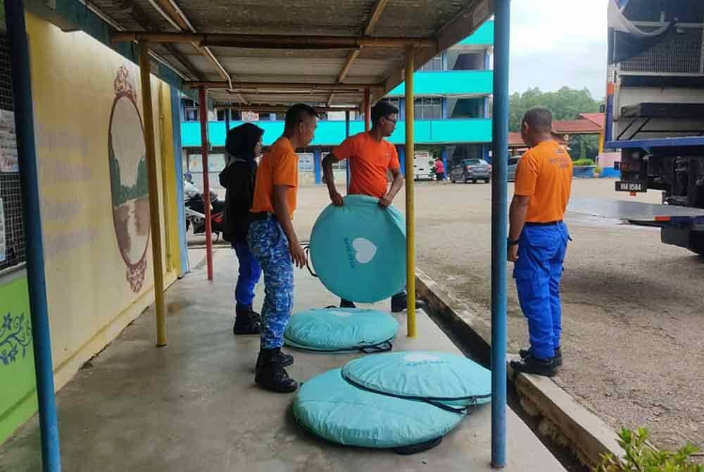 Anggota APM mengemas kubikel di PPS SMK Seri Semantan selepas pusat pemindahan itu ditutup hari ini. Foto APM Temerloh