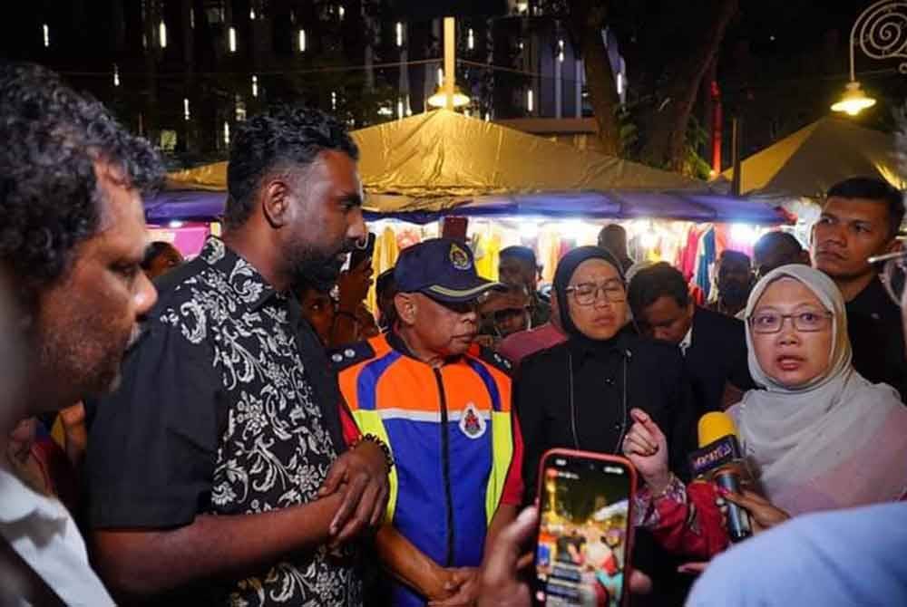 Zaliha (kanan) ketika bertemu peniaga Bazar Deepavali di Brickfields pada Sabtu lalu.