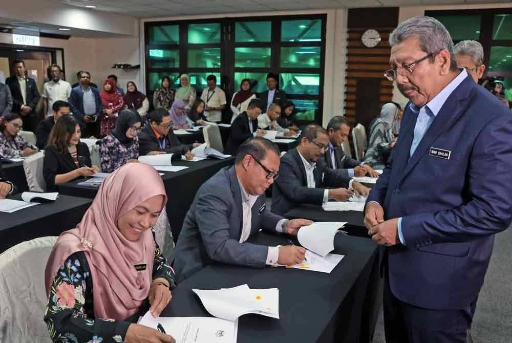 Wan Ahmad Dahlan (kanan) bersama sebahagian daripada 75 orang penjawat awam selepas mengetuai Majlis Menandatangani Opsyen Skim Saraan Perkhidmatan Awam (SSPA) bersama Warga Kerja Jabatan Perkhidmatan Awam (JPA) di Kompleks C, Pusat Pentadbiran Kerajaan Persekutuan Putrajaya pada Isnin.