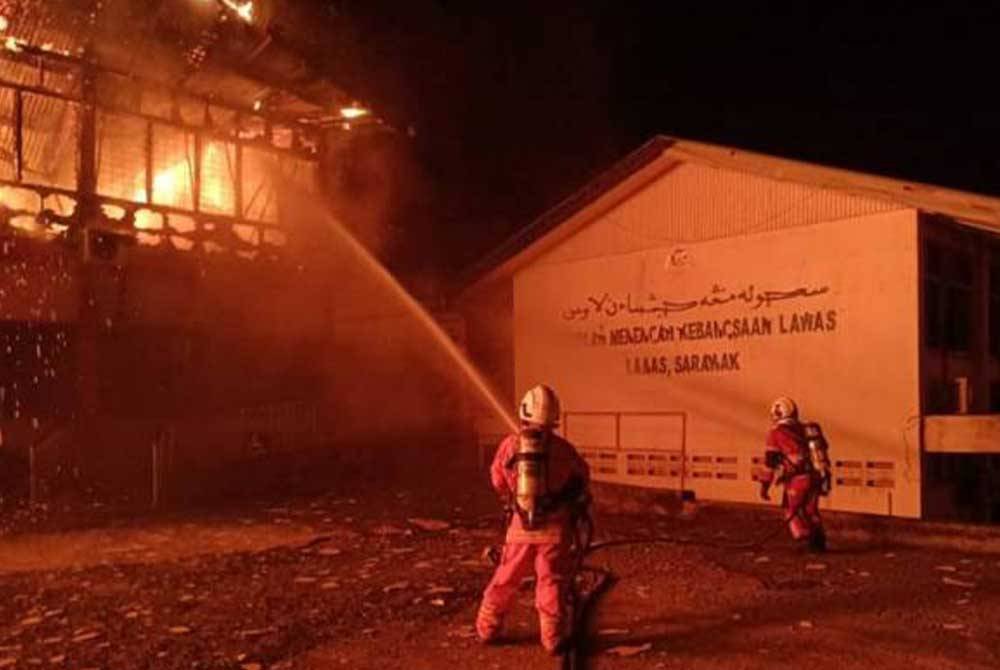 Anggota bomba berusaha memadamkan api pada sebuah blok bangunan Sekolah Menengah Kebangsaan Lawas, Sarawak yang terbakar sekitar jam 11.30 malam tadi. - Gambar ihsan JBPM Sarawak