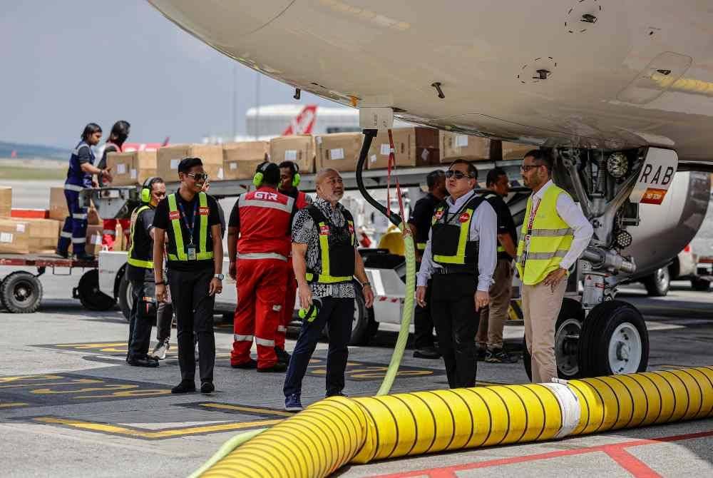 Anthony Loke bersama Ketua Pegawai Pengalaman Lapangan Terbang dan Pelanggan AirAsia Aviation Group, Kesavan Sivanandam (kanan), meninjau penggunaan Unit Kombo cekap tenaga, inisiatif baharu AirAsia untuk mengurangkan pelepasan karbon, pada majlis perkenalan alat tersebut di KLIA Terminal 2, pada Selasa. Foto Bernama