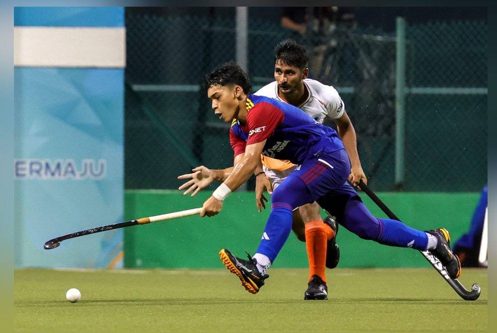 Pemain Malaysia, Adam Ashraf (kiri) diasak oleh pemain India, Yadav Chandan (kanan) pada Perlawanan Hoki Piala Sultan Johor (SOJC) di Stadium Hoki Taman Daya pada Selasa. Foto Bernama