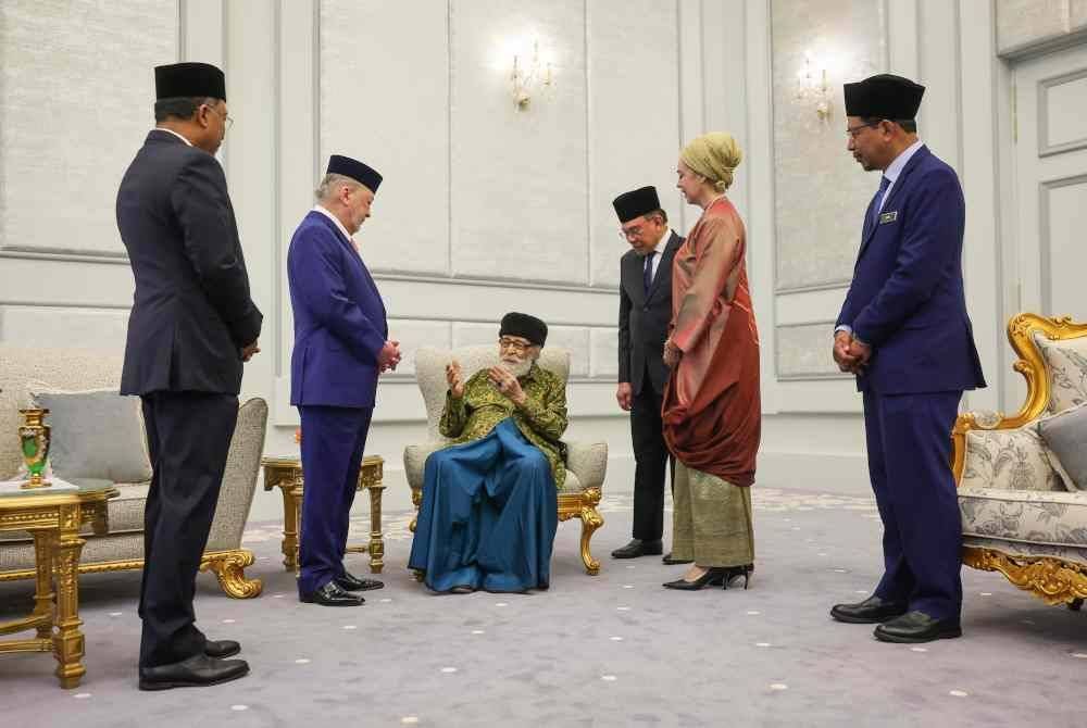 Sultan Ibrahim berkenan beramah mesra dengan tokoh intelek Islam Tan Sri Dr Syed Muhammad Naquib Al-Attas (tiga, kiri) pada majlis pengurniaan watikah pelantikan profesor diraja di Istana Negara hari ini. Foto Bernama