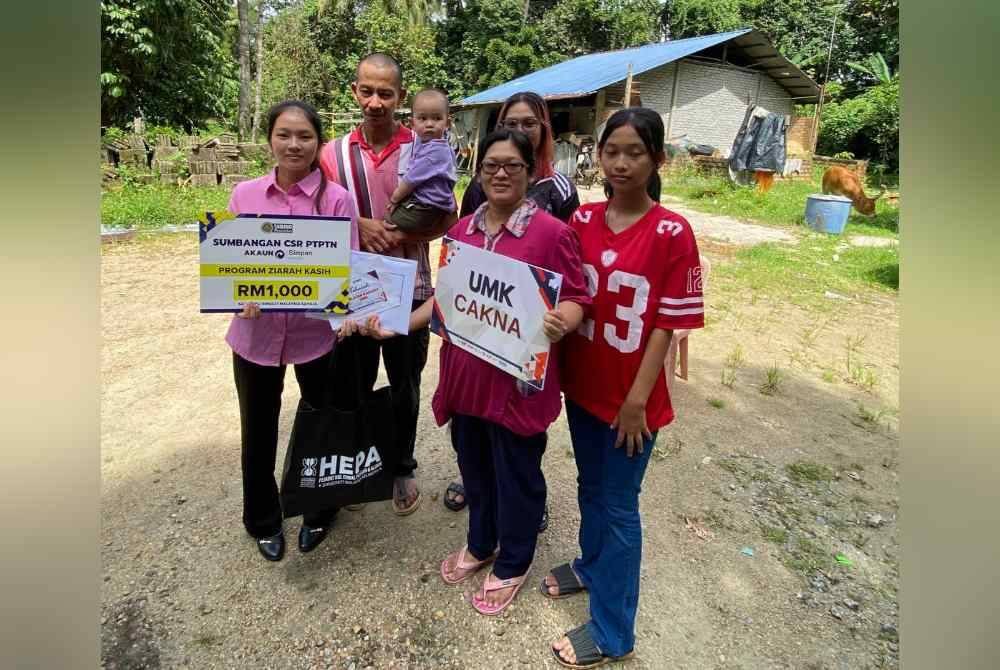 Vivian (kiri) berkongsi kegembiraan bersama ibu, ayah dan adik-adiknya di hadapan rumah mereka di Kampung Pasir Parit, Chekok di Pasir Mas