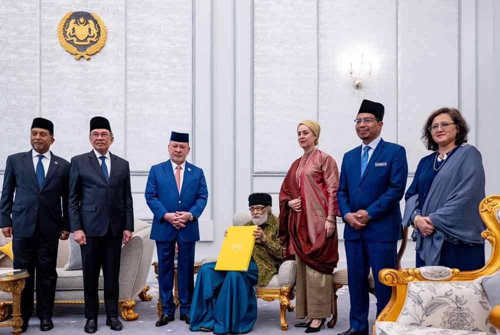 Yang di-Pertuan Agong Sultan Ibrahim (tiga dari kiri)berkenan mengurniakan watikah pelantikan profesor diraja kepada tokoh intelek Islam Tan Sri Dr Syed Muhammad Naquib Al-Attas (duduk) di Istana Negara pada Rabu.