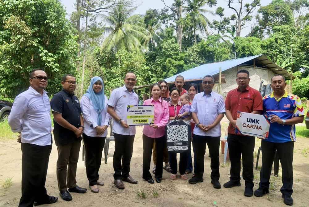 Ketua Eksekutif PTPTN, Ahmad Dasuki Abdul Majid (empat dari kiri) menyerahkan replika kad sumbangan CSR PTPTN kepada Vivian Koh Lik Ting di Pasir Masir, Kelantan.