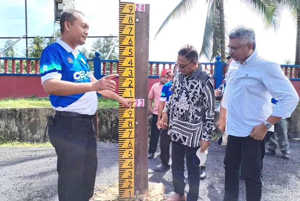 Hanafiah (tengah) bersama ADUN Hulu Besut, Mohd Husaimi Hussin (kanan) dan Osman ketika hadir pada Program Ramalan dan Amaran Banjir Fasa 2 di Kampung La, Hulu Besut pada Khamis.