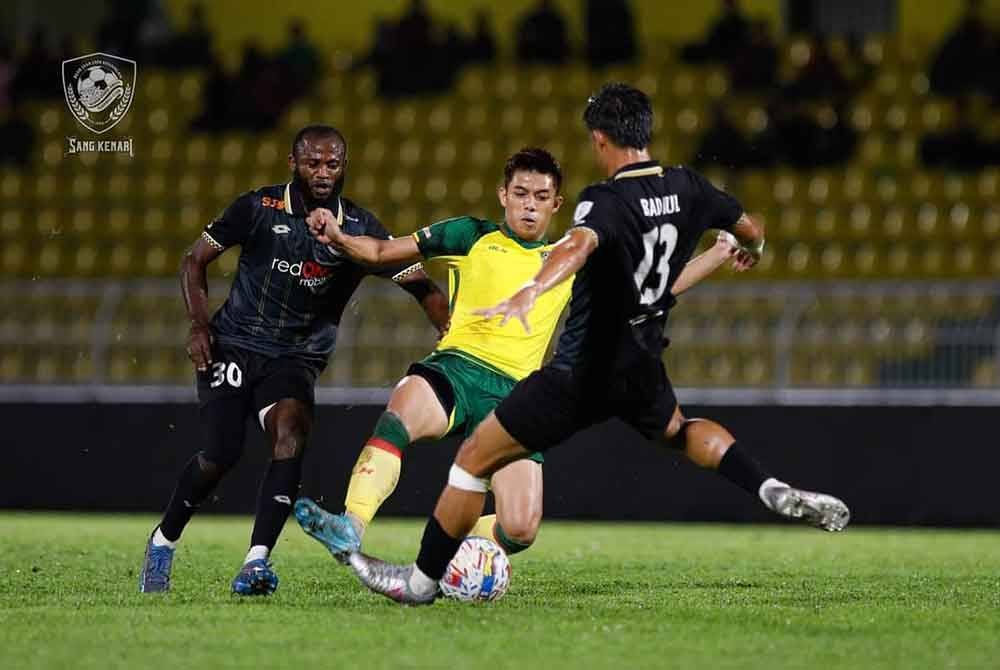 Penyerang KDA FC, Syafiq Ahmad (tengah) dikawal ketat dua pemain PDRM FC pada aksi Liga Super di Stadium Darul Aman pada malam Jumaat. Foto KDA FC