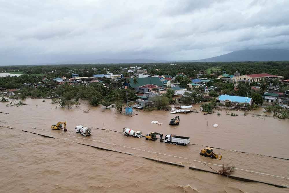 Perkampungan dan kenderaan pembinaan yang ditenggelami banjir akibat hujan lebat dibawa oleh Trami di bandar Bato, wilayah Camarines Sur, Filipina.