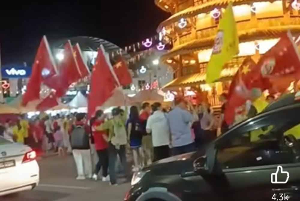 Tangkap layar video tular mempamerkan peserta negara China mengibar bendera negara itu ketika perarakan sambutan Guan Gong Sedunia di Teluk Intan.