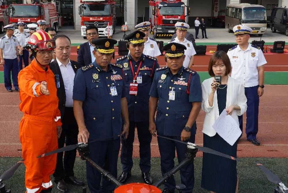 Othman (depan, dua dari kiri) mendengar penerangan pengendalian dron daripada seorang pegawai agensi penyelamat China semasa kunjungan agensi keselamatan negara ke negara republik itu, baru-baru ini. Foto: JBPM