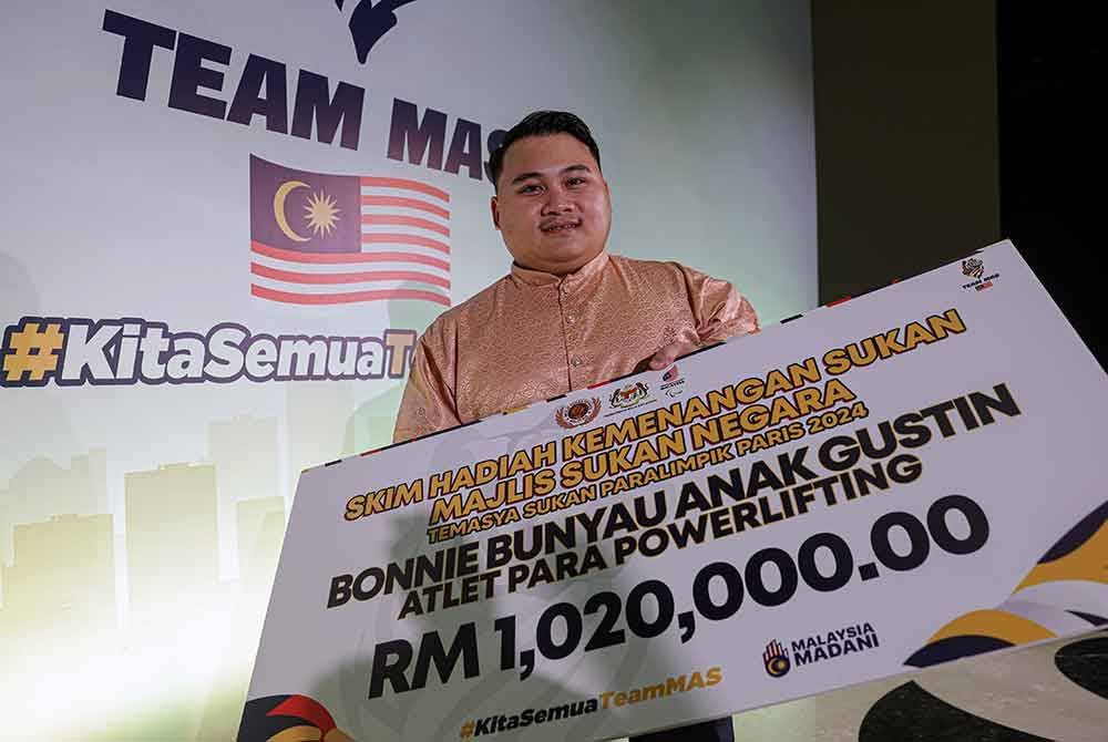 Atlet powerlifting Bonnie Bunyau Gustin bersama replika cek Skim Hadiah Kemenangan Sukan yang diterima setelah memenangi pingat Emas dalam Temasya Sukan Paralimpik Paris 2024 di sebuah hotel, pada Jumaat. Foto Bernama