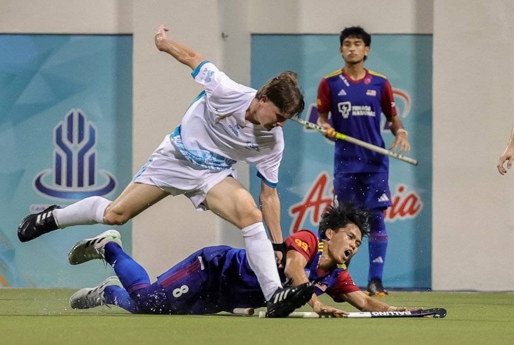 Pemain Young Tigers, Andywalfian Jeffrynus (tengah), diasak pemain Australia Angus Adamson pada Piala Sultan Johor di Stadium Hoki Johor, Taman Daya. Foto Bernama