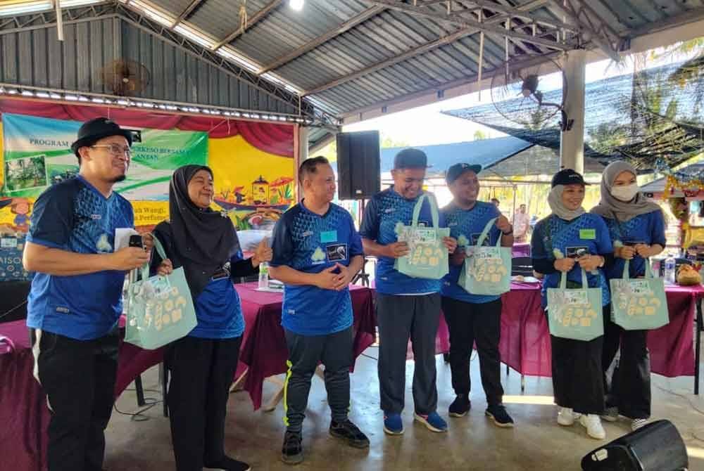 Nora (dua dari kiri) menyampaikan hadiah kepada kakitangan yang menyertai sukan sempena Program Tautan Kasih PERKESO Bersama Media Kelantan pada Jumaat.