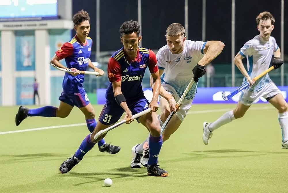 Pemain Young Tigers, Nur Aqilrullah Che Mohd. Khairulzi Anuar (dua, kiri) diasak pemain Australia, Dylan Downey pada aksi Piala Sultan Johor di Stadium Hoki Johor, Taman Daya.