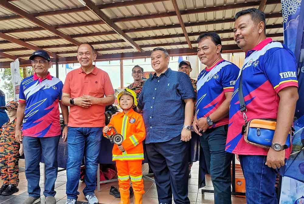 Rahmad (dua dari kanan) dan Rais (tiga dari kanan) bersama bomba cilik ketika Karnival Sejahterakan Bandarayaku DUN di Kompleks JAPERUN Ayer Molek pada Sabtu.