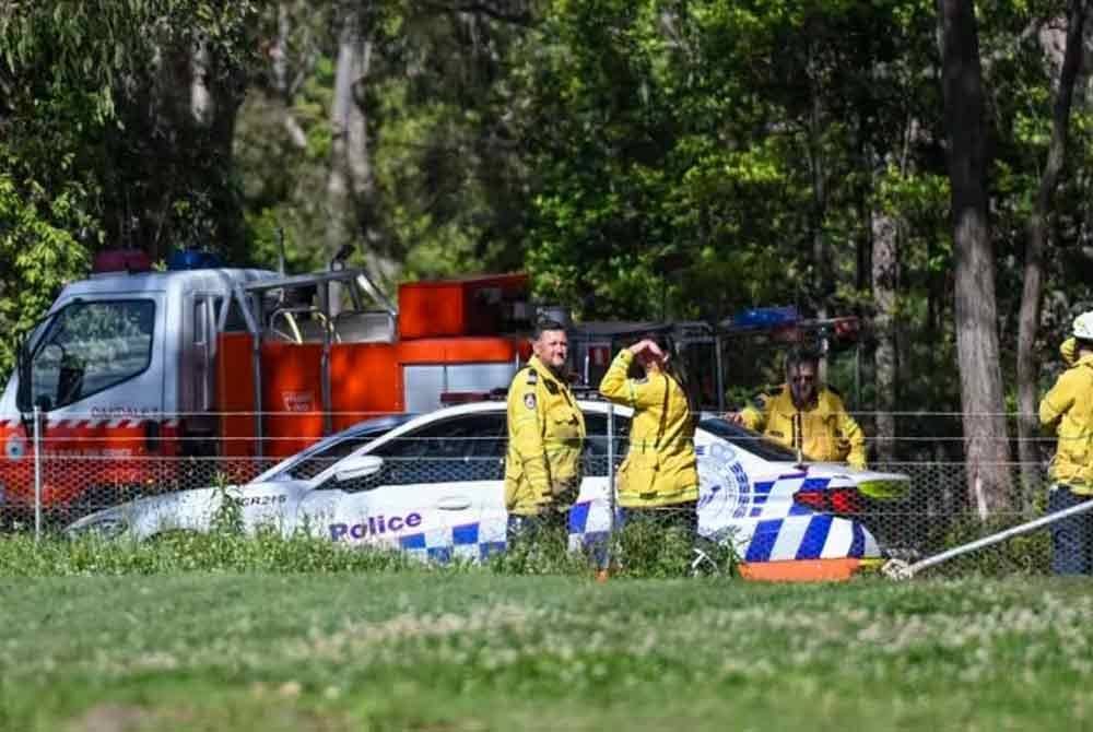 Anggota polis dan bomba berada di kawasan dua pesawat ringan bertembung di udara dan terhempas ke kawasan hutan di barat daya Sydney pada Sabtu - Foto: AP